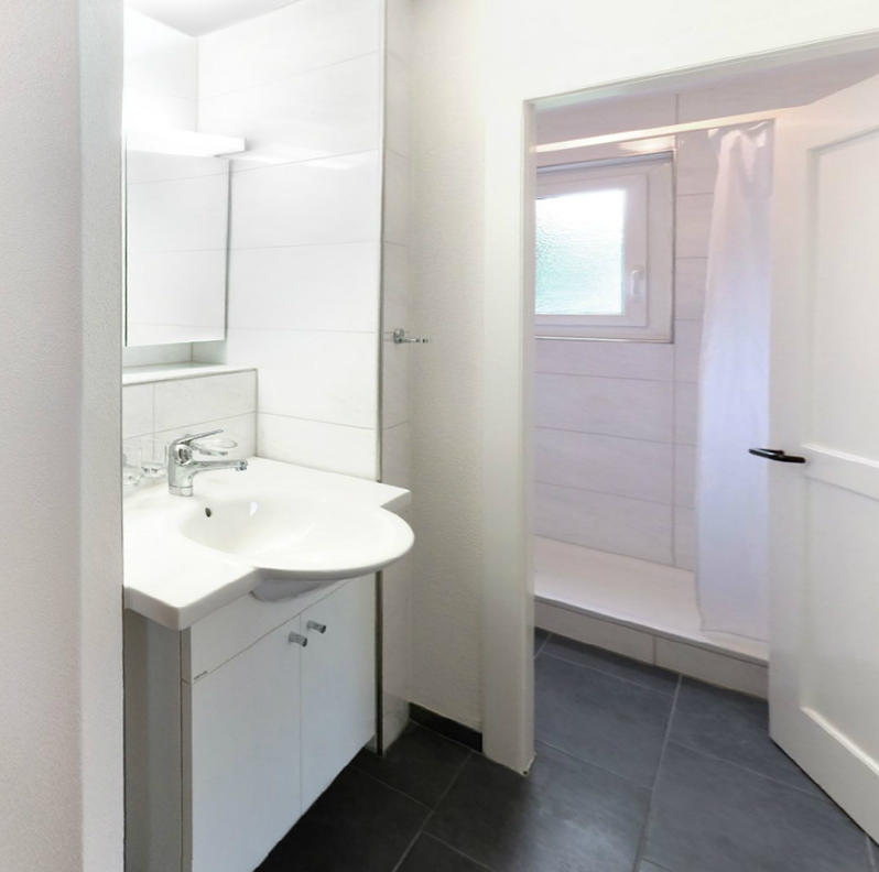 Helles Badezimmer mit Dusche in einer Mettfeld-Wohnung.