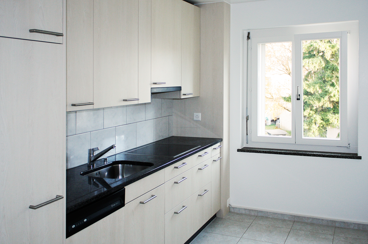 Moderne Küche mit Fenster ins Grüne in einer Mühlefeld-Wohnung.